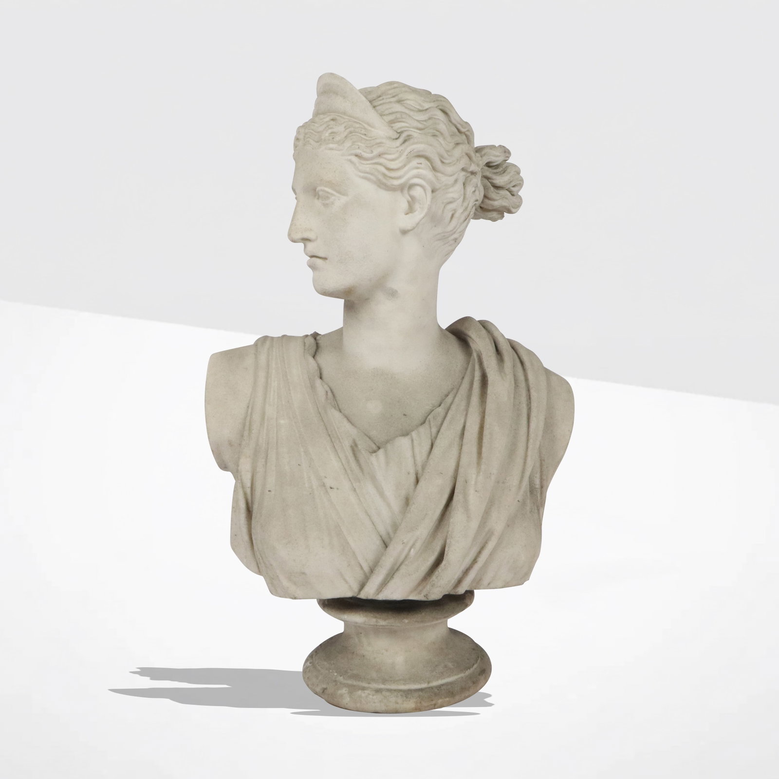 Neoclassical Carved Marble Bust of Diana: Neoclassical carved marble bust of Diana, 19th century, with an unattached socle. [31" H x 21" W x 15" D]. Condition is good with wear and pitting throughout commensurate with outdoor placement.