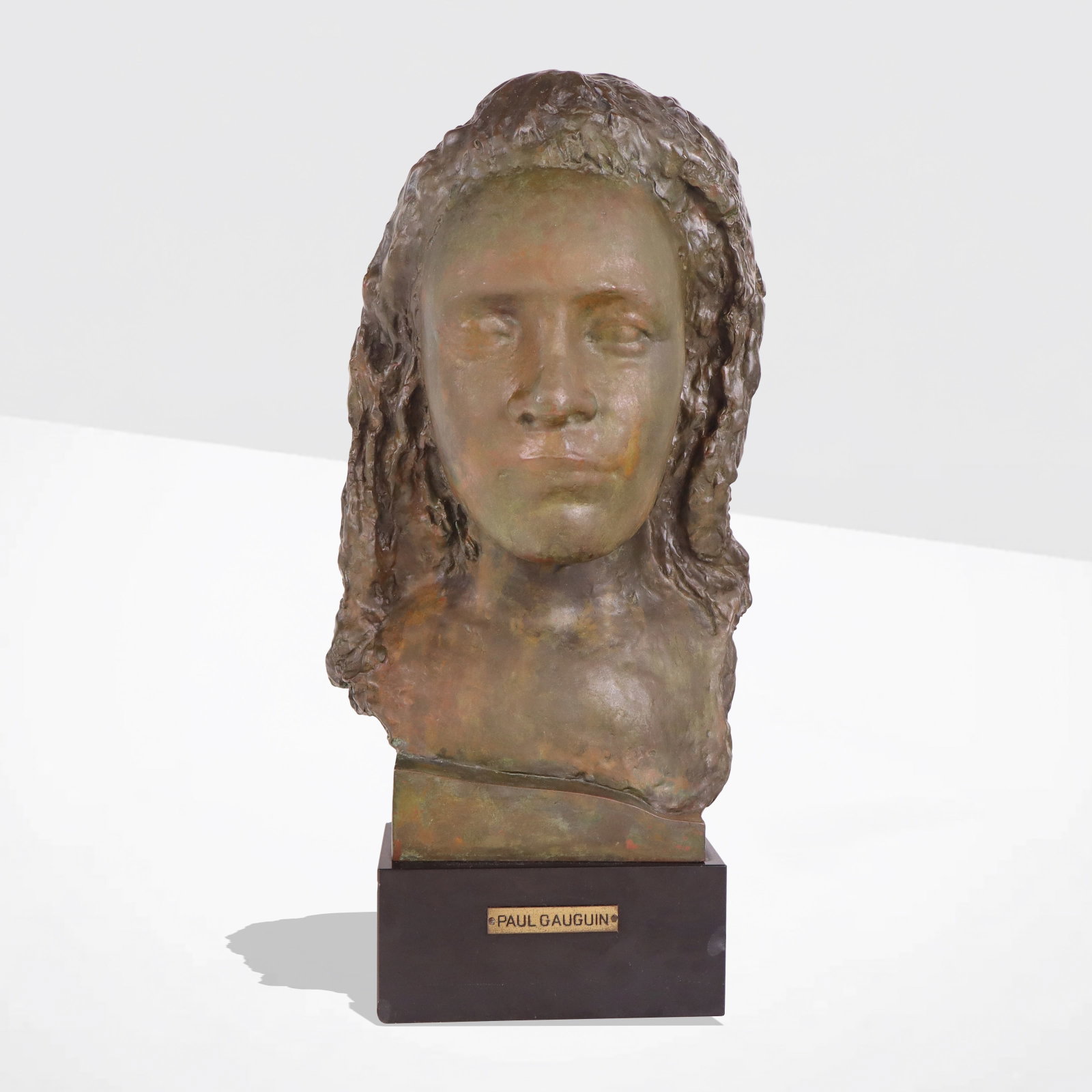 After Gauguin "Masque d'une Femme" Bronze: After Paul Gauguin "Masque d'une Femme," bronze bust, 20th century, on a black marble base, marked Paul Gauguin to plaque at lower, bronze apparently unmarked. [Including marble base: 19" H x 10" W x 