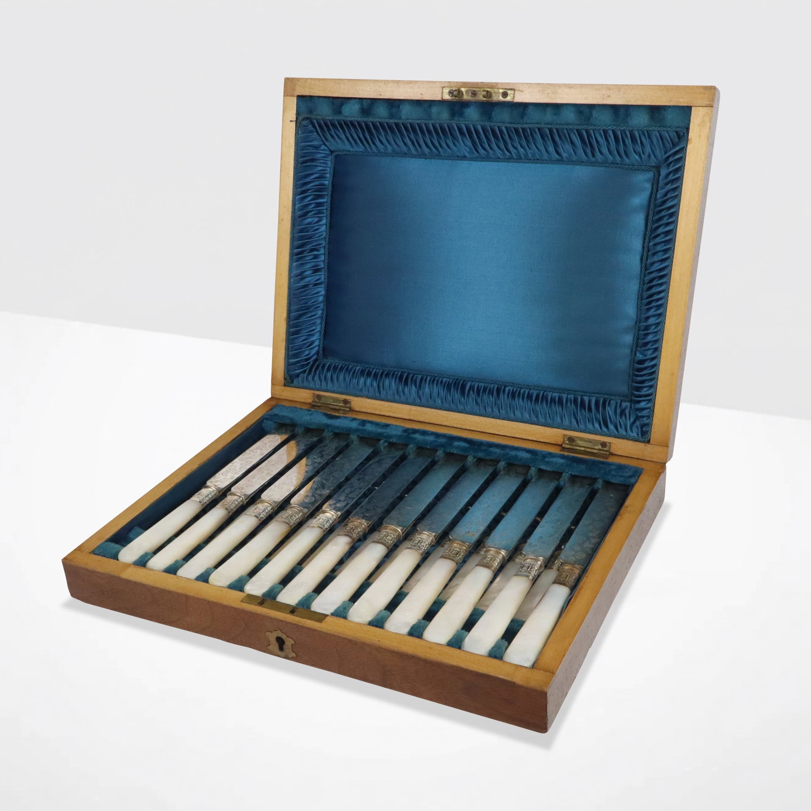 Victorian Silver Plate & Mother of Pearl Fruit Set: Victorian silver plate fruit and leaf engraved and mother-of-pearl fruit set for twelve in fitted box, unmarked, knives engraved on one side of blade. [Box: 2.5" H x 12" W x 9" D] Overall condition is