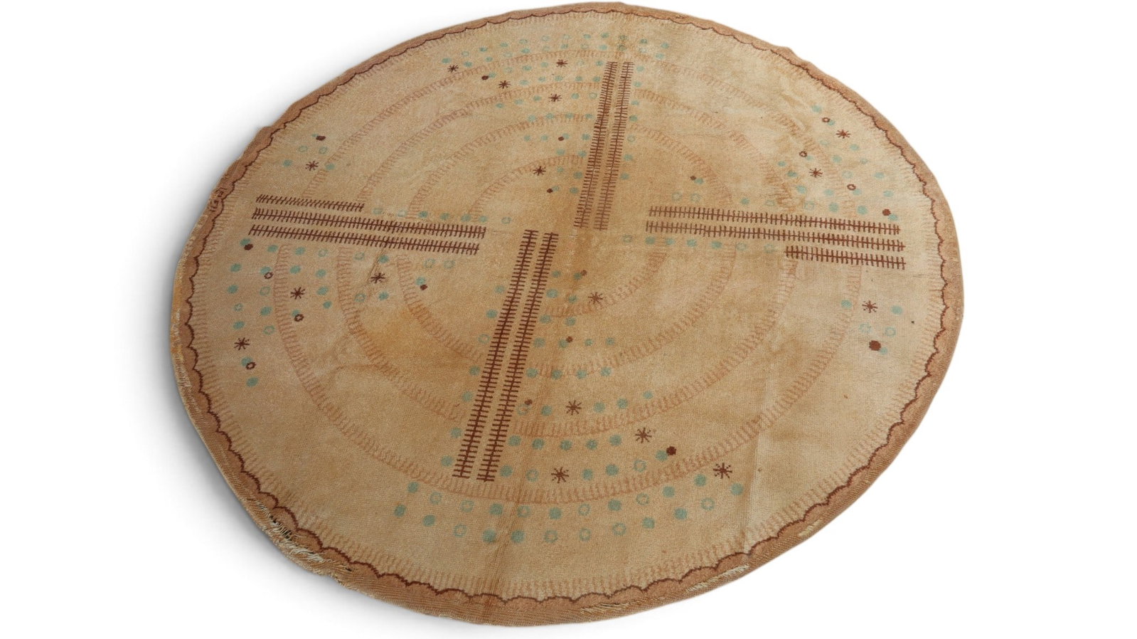 Tan Round Decorated Rug: Round decorated rug, having a tan ground with dark brown and blue geometric details. [115" Diameter]. As-is, repairs, tears, holes, worn condition.
