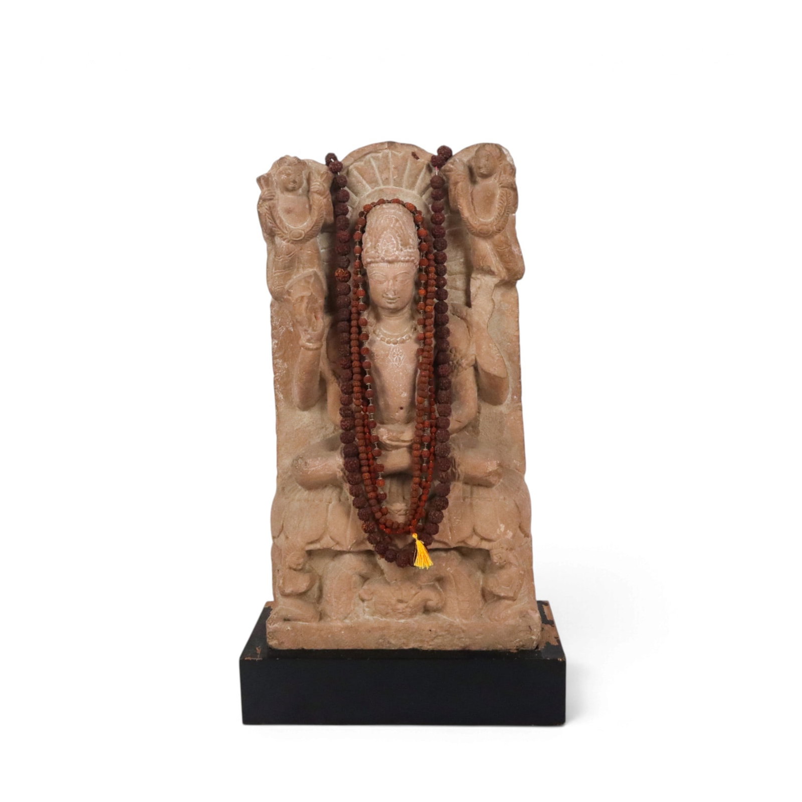 Carved Indian Sandstone Sculpture: Carved sandstone sculpture, Indian, 20th century, depicting a Hindu deity and having a one-sided figural composition depicting a deity seated in lotus position on a lotus-form base above attendant fig