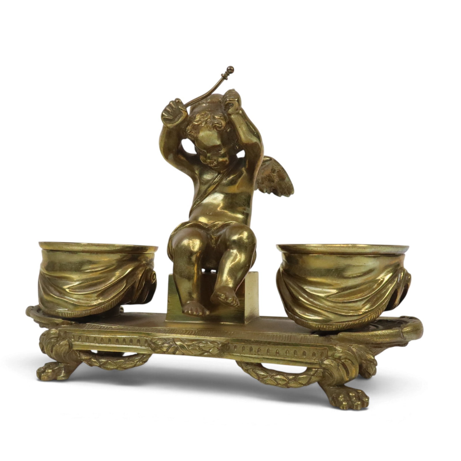 Regence Gilt Bronze Inkstand: Regence gilt bronze figural inkstand, late 19th/early 20th century, designed with a putto, drum stick poised overhead, seated between drum form inkwells all resting on a tapestry with hairy paw feet. 