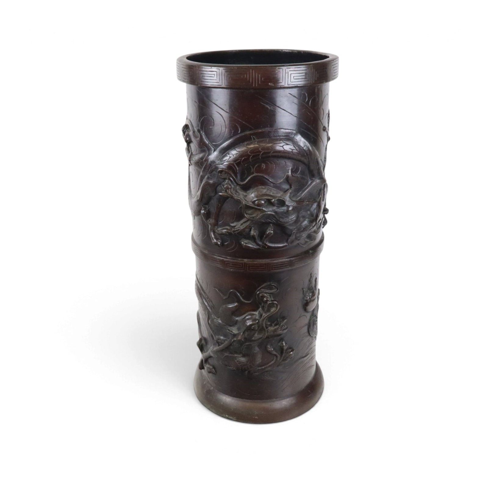 Japanese Bronze Umbrella Stand: Japanese bronze umbrella stand, Meiji period, of cylindrical form with high relief decoration displaying two scenes - the lower section of a dragon emerging from the sea and wish-fulfilling jewel, the