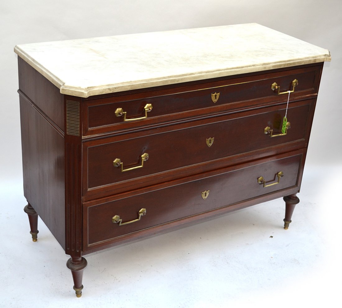 French Directoire Commode: Three drawer commode with a white beveled marble top, fluted legs, stamped "Brunovani Inc." Missing applique on right corner. [46 3/4" x 21 1/2" x 35" H].