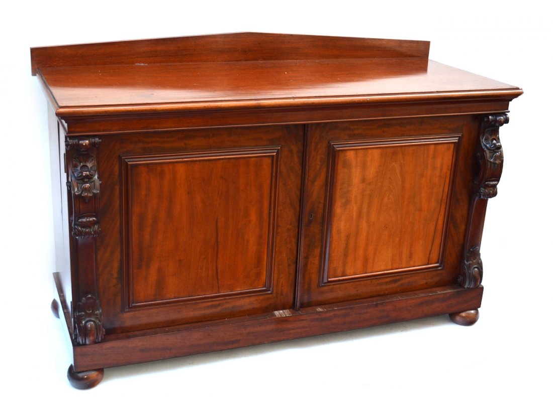 19th Century English Mahogany Sideboard: Featuring boldly carved Renaissance Revival stiles at either side, backsplash and bon feet, with an interior fitted for an entertainment center. Bears hinged sides. [66" x 24 1/2" x 43 1/2" H].