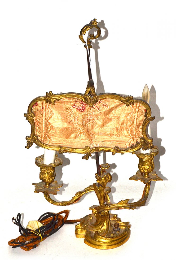 Electrified Antique Bronze Candelabra: Rococo Revival two arm lamp with an adjustable silk shade in a cartouche form frame. [9 5/8" x 4 3/8" x 16 3/4" H].