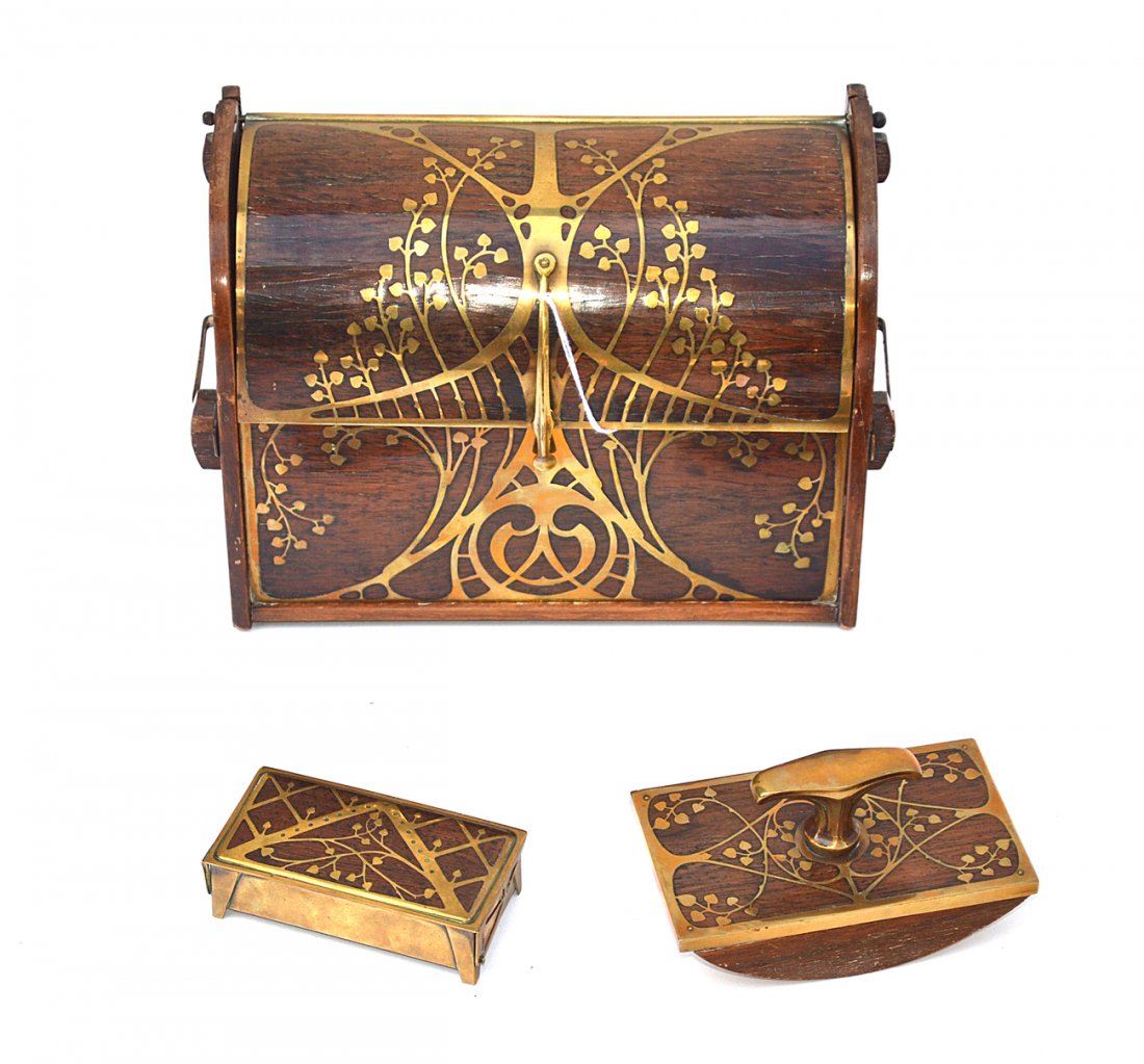 Art Nouveau Brass Inlay Desk Set: All bear leafy tendril motifs. Comprises 1) Hinged top letter safe. [10" x 4 1/2" x 7"]. 2) Stamp box [4" x 2" x 11 1/8"]. 3) Blotter rocker with brass handle. [4 7/8" x 2 7/8" x 2 5/8"]. Wear consist