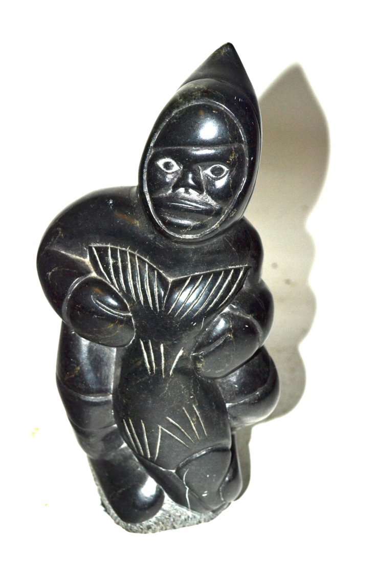 Inuit Soapstone Sculpture, Fisherman with Salmon: Standing full-length depiction of a fisherman holding a large salmon. 5" W x 2 7/8" D x 9 1/8" H. Bottom bears a Canadian Eskimo art label and is inscribed with inventory number. Scuffs and scratches.