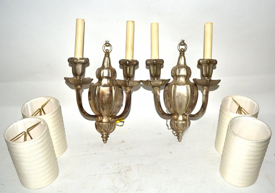 Pair of Caldwell Silver Finish Sconces: Two-arm sconces with blaustrade-form back plates tapering at top and bottom. Each bear Caldwell's "C" inside diamond mark. [9" W x 5 1/8" D x 15" H]. Both in good condition.