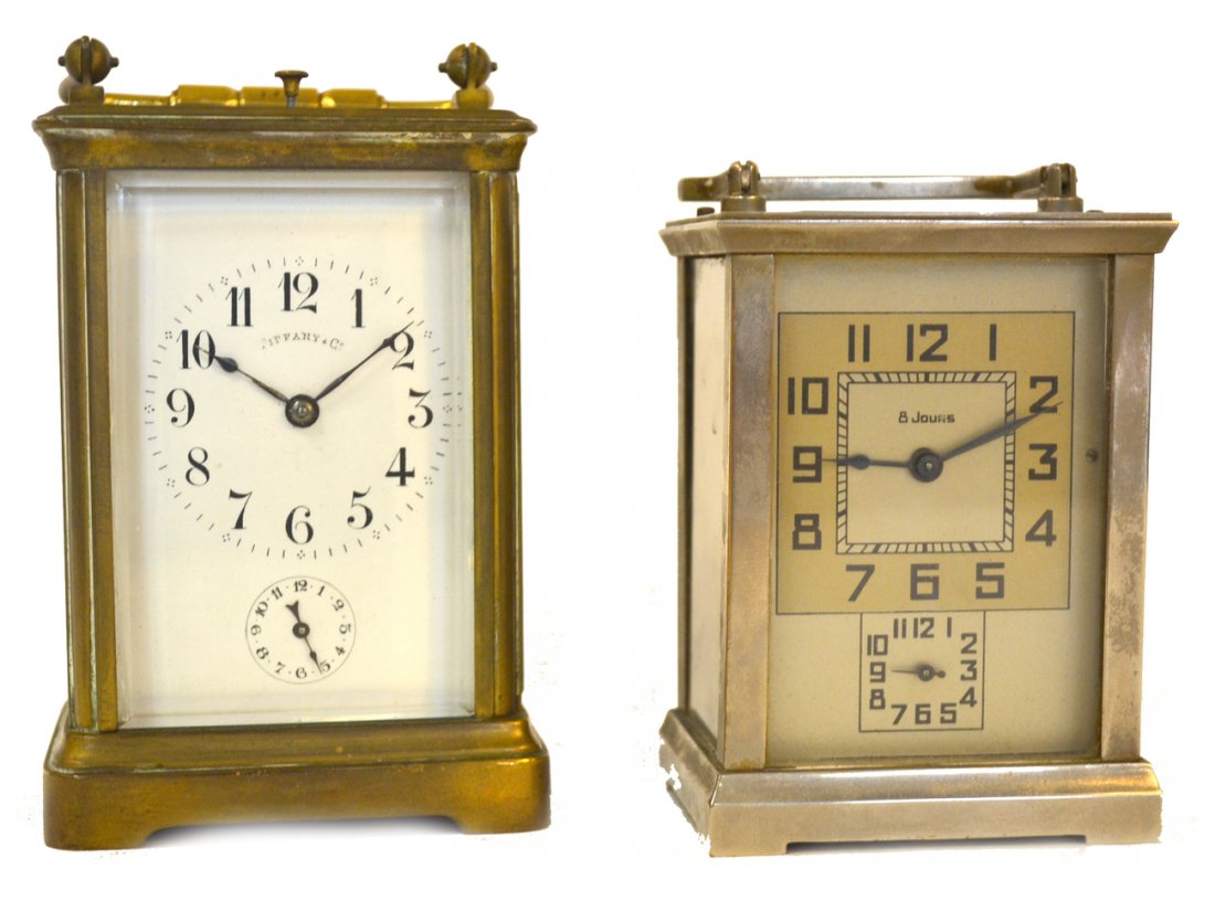 Two Carriage Clocks - Tiffany and Other: Comprises 1) Tiffany & Co. clock with bronze fittings and five beveled clear glass panes. Bears an enamel faceplate, French movement and chime 2) Art deco nickel silver finish clock with four clear gl