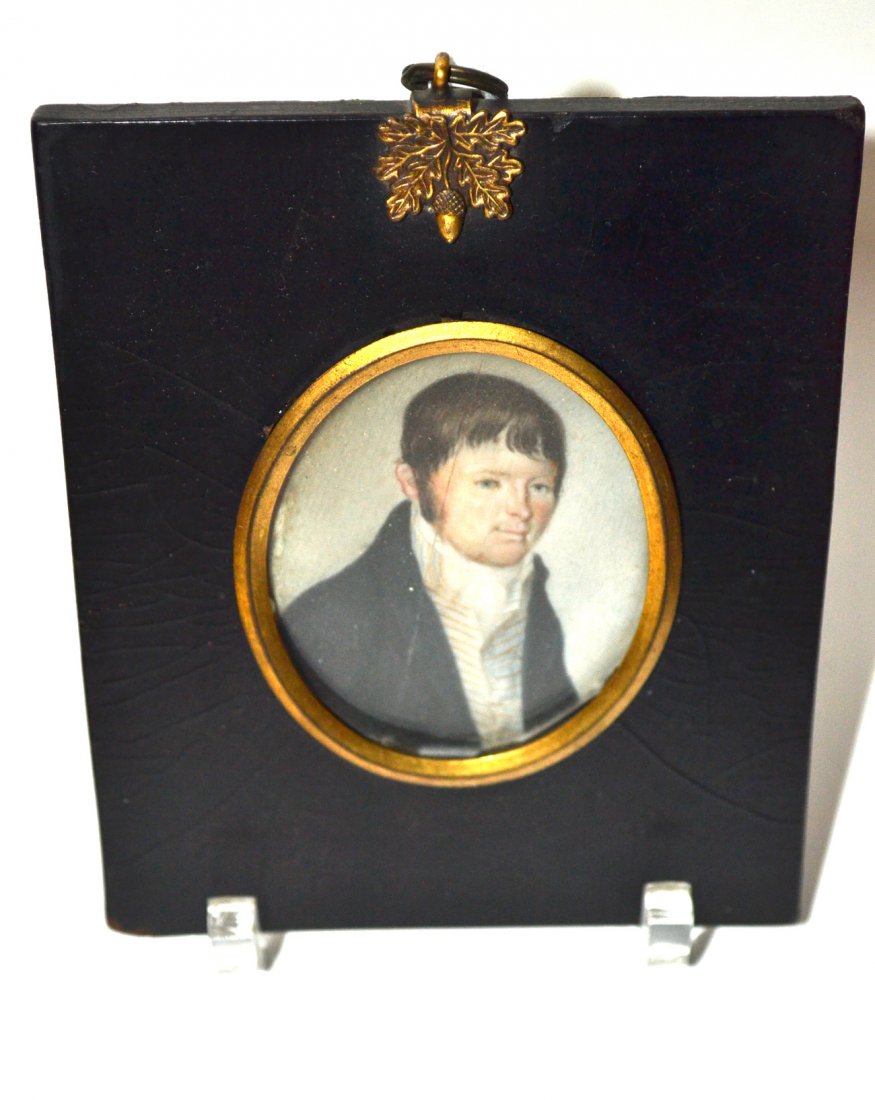 Antique American Miniature Portrait on Ivory: Oval portrait of a man in a bust length 3/4 profile pose wearing 18th/19th century costume. [Oval 2 1/2" x 2" contained under glass in a black frame 4 7/8" x 4"]. Vertical crack at center left affecti