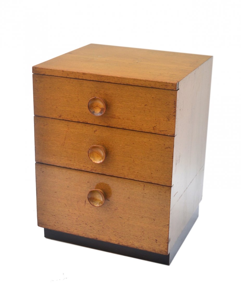 Gilbert Rohde Bedside Stand: Mid-century modern three-drawer chest with circular turned wood pulls. 18 1/4" w x 18 1/4" d x 24" h. Wear throughout, sold "as is".