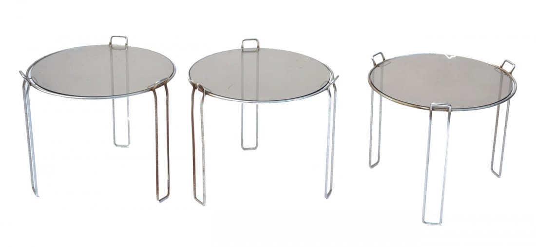 Mid-Century Modern Nesting Tables: Set of three side tables with circular smoked glass tops on chromed steel three-leg supports. [16 1/2" dia x 16" h]. Pitting on chrome and oxidation.
