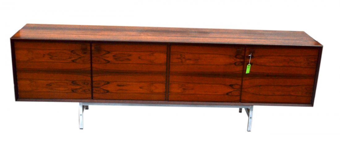 Scandinavian Mid-Century Sideboard: Rosewood sideboard on chromed steel supports. Bears four doors concealing three compartments: left - two shelves; right - two recessed shelves and five drawers. Interior spaces all white ash. Light we