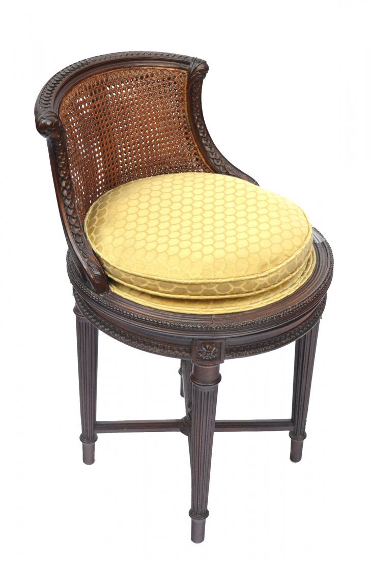 Louis VXI-Style Piano Chair: Carved walnut caned back revolving piano stool. In good condition. [27" h x 16" w x 20" to seat].