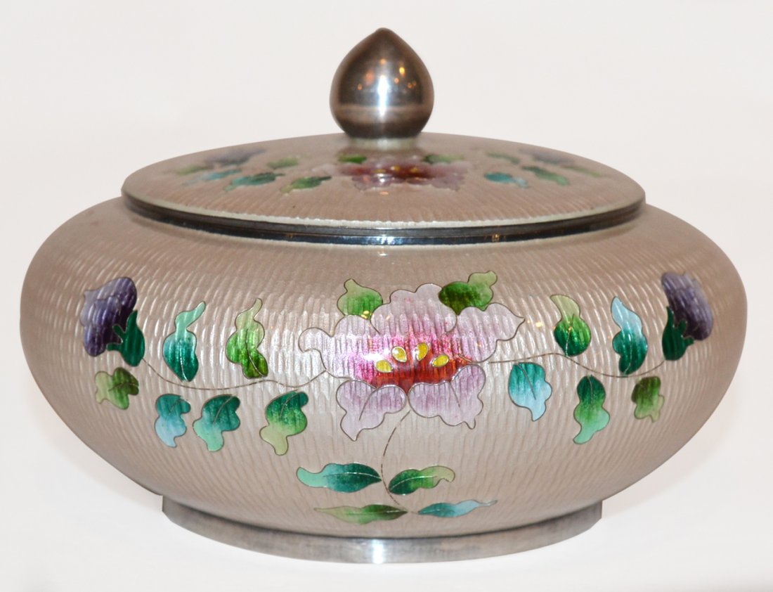 Asian Silver & Enameled Box: The circular box having a white enameled and textured ground and floral decoration. High grade (99%) silver content. In good condition. [3 1/4" h x 5 1/4" dia]