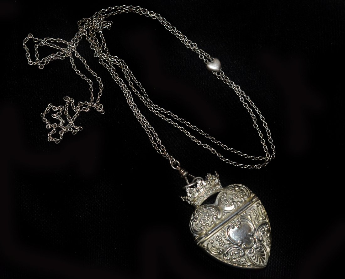 Victorian Silver Locket or Charm: Having a long silver chain with a heart-shaped hinged pendant in the form of a heart. The hinge closes securely, the chain is original to the piece. It is marked "FB" and "Sterling", in very good cond