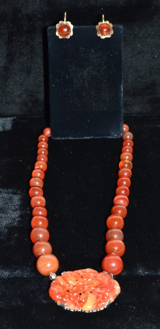 Chinese Carnelian Choker and 14k Gold Earrings: Comprises 1) Choker composed of 38 graduated carnelian beads with a reticulated oval pendant. Contained in a silver sterling frame. 2) Pair of hardstone cabochon earrings with 14k gold flower-form set
