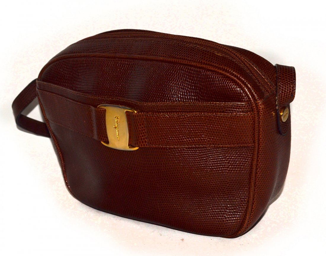 Ferragamo Handbag: Lizard textured leather. Bears one exterior compartment with one interior compartment with zipper closure. [9" w x 3 1/4" d x 7" bag only]. Interior bears powder residue. Otherwise good condition.