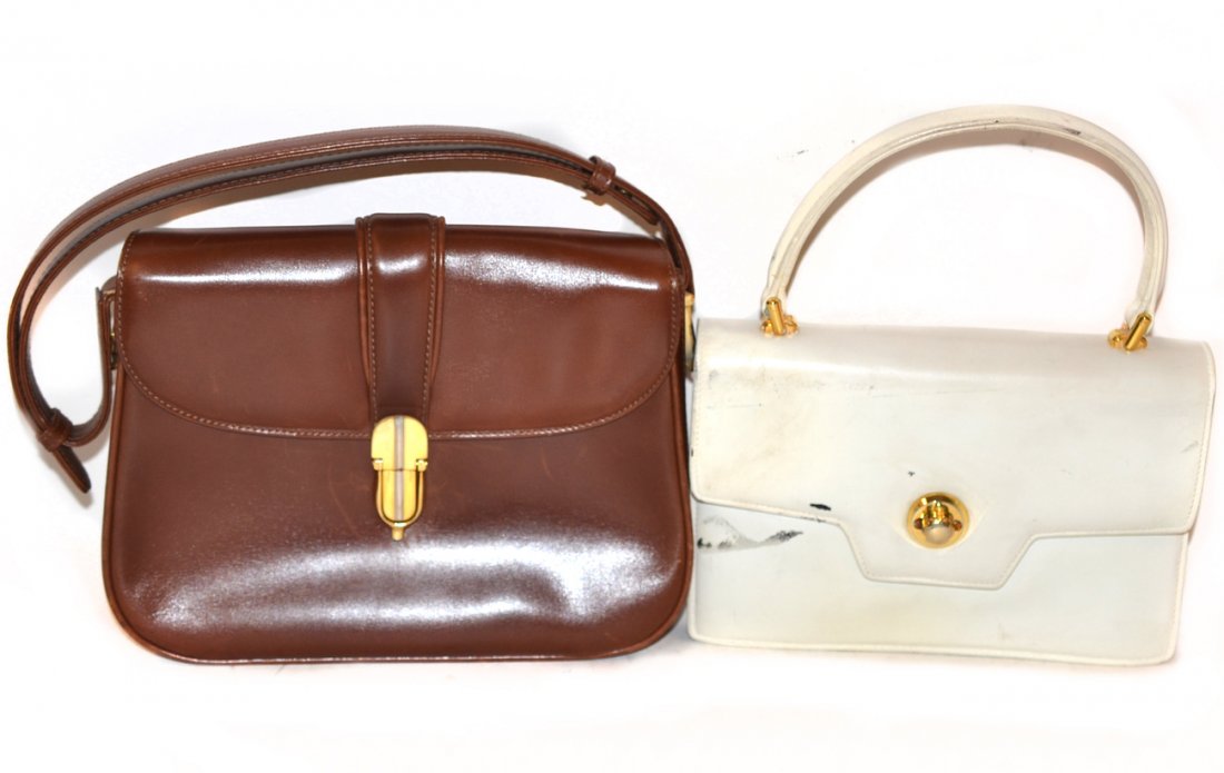 Two Vintage Gucci Handbags: Comprises: 1). White bag with fold over flap closure. [9" w x 3" d x 6 1/4" h]. Some scuffs and stains. 2). Brown leather bag with adjustable strap. Five interior compartments. Some light scratches. [