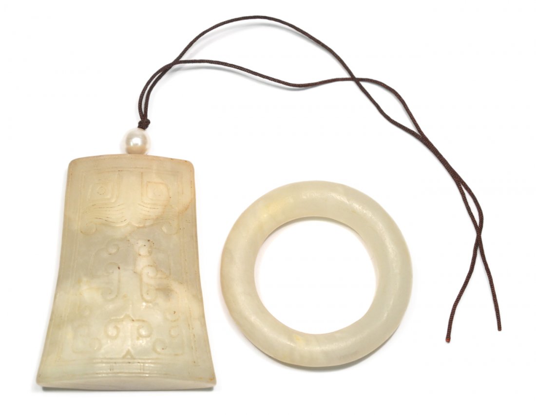 Two Asian Mutton-Fat Jade Articles: Comprises a ring [2 1/2" Dia] and a bell form pendant with low relief dragon decor. [2 3/16" W x 5/8" x 2 7/8" H]