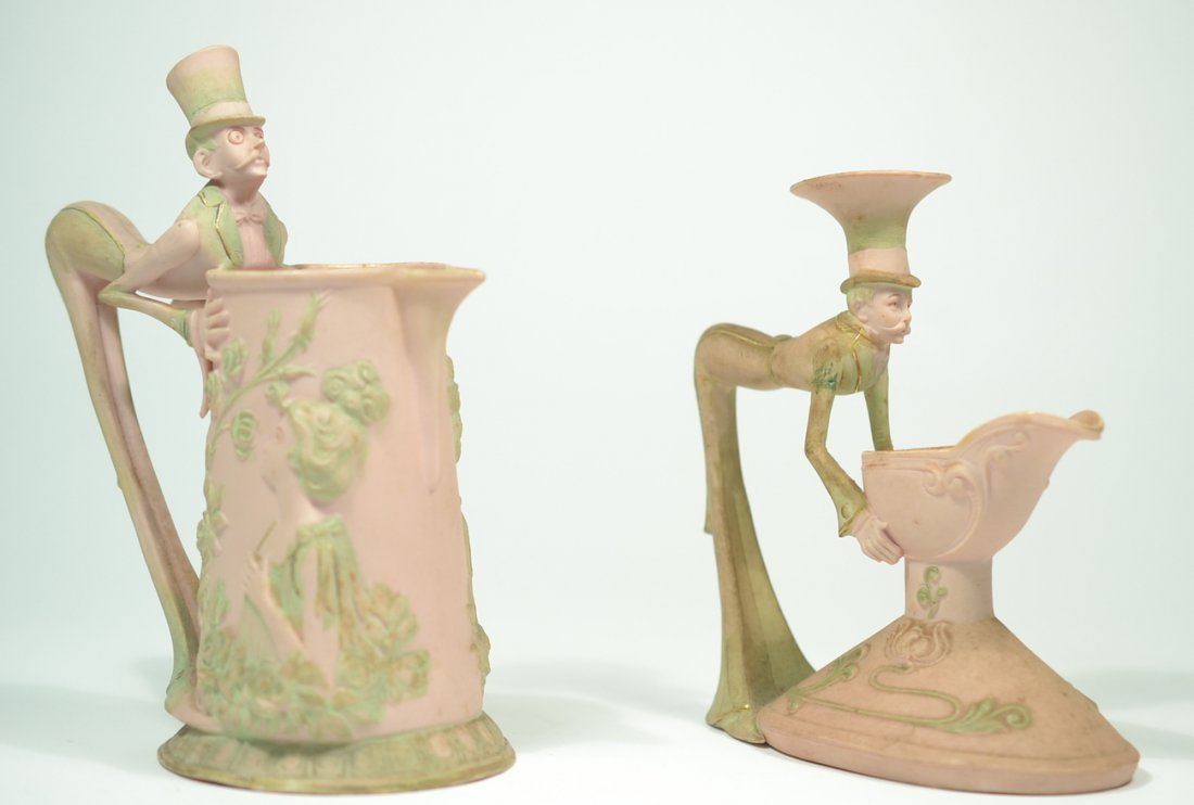 Schafer & Vater 'Alice in Wonderland' Creamers: Two whimsical pink bisque porcelain figural creamers. One 5" W x 3" D x 6" H (stamped "ill."on bottom), the other 4 1/4" W x 2 1/4" D x 5" H (stamped on bottom "3837"). Soiling and stains, otherwise c