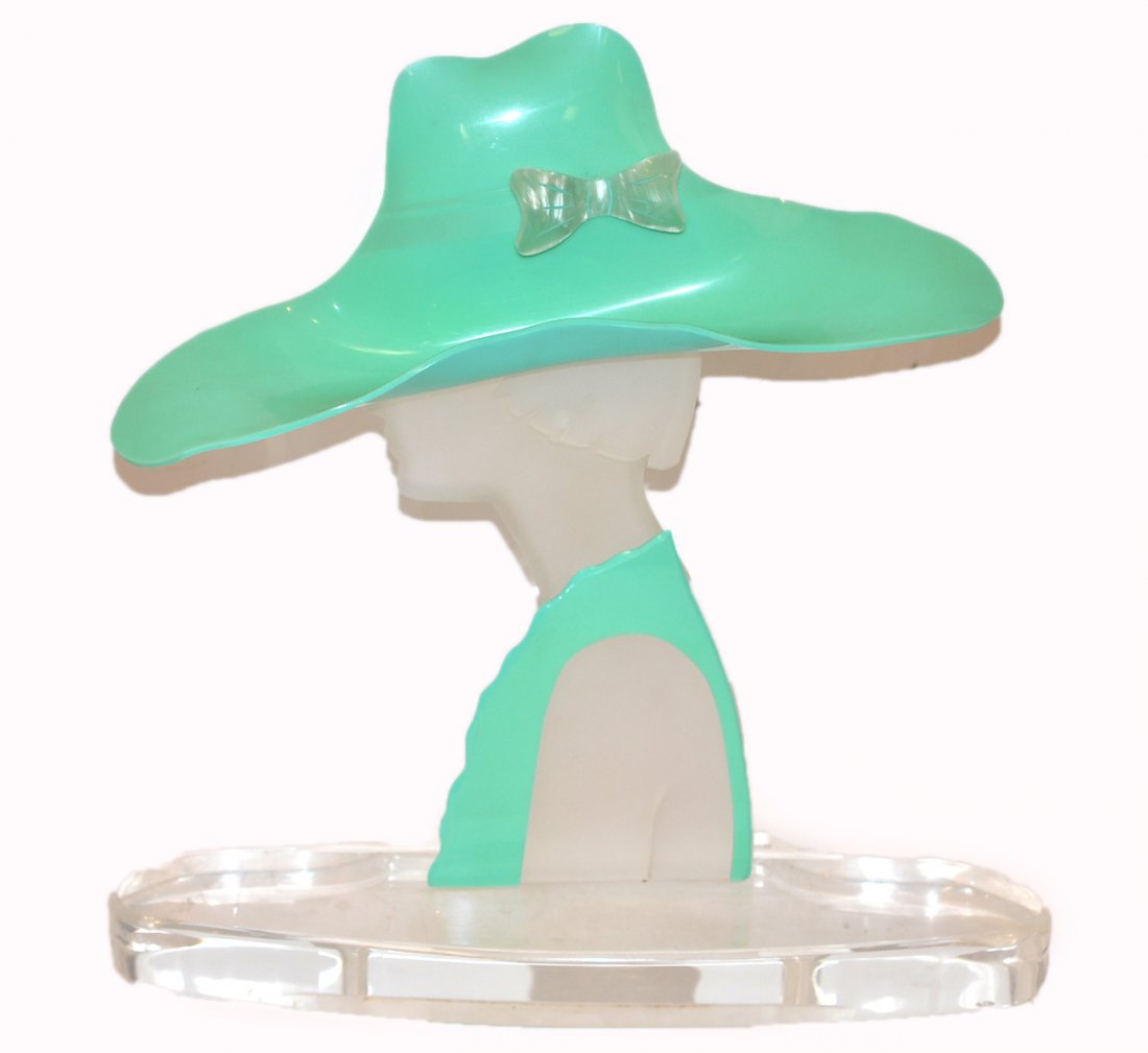 Modern Acrylic Sculpture: Features a woman in profile wearing a large hat, modeled in clear, frosted green acrylic. In good condition. [18 1/4" h x 18" w x 4 3/4" d]