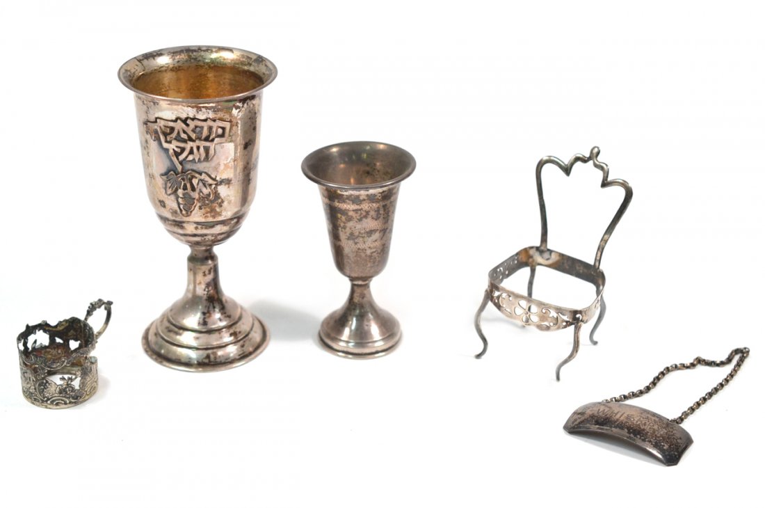 Assorted Silver Articles: Comprises two kiddush cups, bottle tag, miniature model of a chair, and cup holder. 3.76 ozt., weighable.