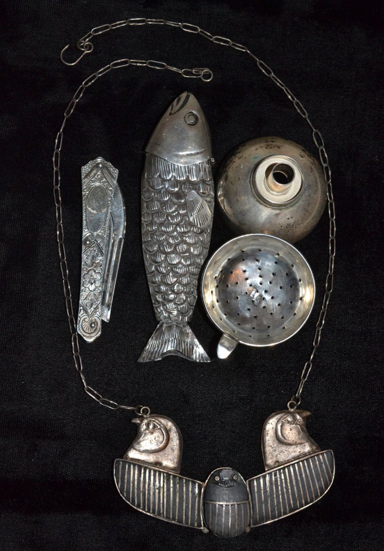 Four Silver Articles: Includes scarab necklace, pocket knife, strainer and fish-form case. [Length of fish 4 1/2"]. 4.3 ozt inclusive All in good condition.