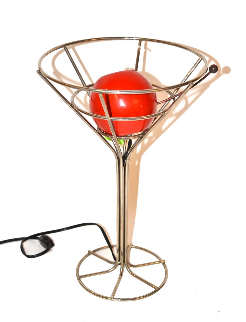 Mid-Century "Cocktail Glass" Lamp: Chromed martini glass form frame with light bulb cased in enameled cherry. Good condition. [14 1/2" high].