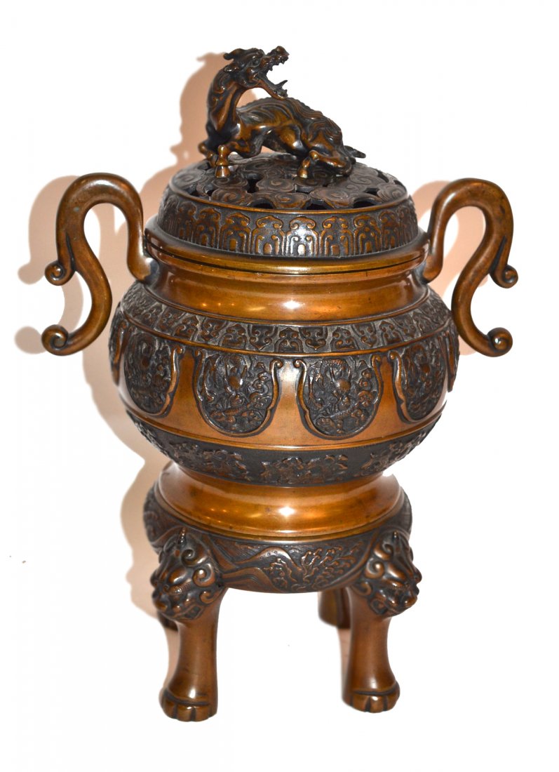 Large Chinese Bronze Censer: Covered censer with a dragon surmount sitting on a footed base mounted with four foo lion masks. [14 1/4" h].