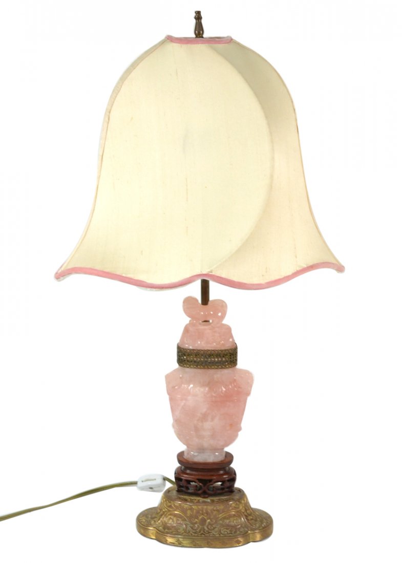 Chinese Rose Quartz Lamp: Finely carved rose quartz urn mounted on a repoussé bronze base. [Overall height: 22"]. In good condition.