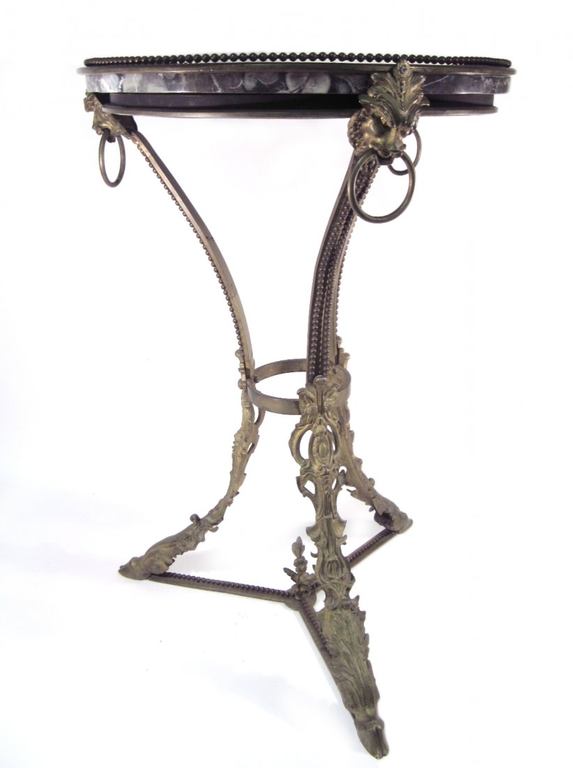 French Gueridon: Ornate gilt bronze marble inset gueridon with beaded trim, lion motif, and hoof feet. [27 3/4"H x 18" dia]. Loose frame.