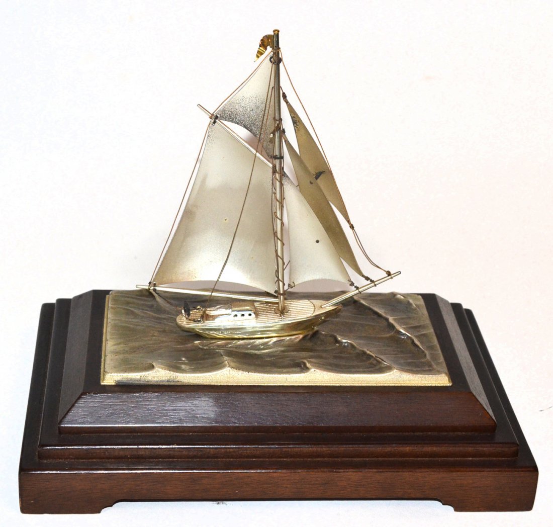 Silver Model of a Sailboat: On a wood base. [8 3/4" x 5 3/4" x 7 3/4" H]. Good condition.