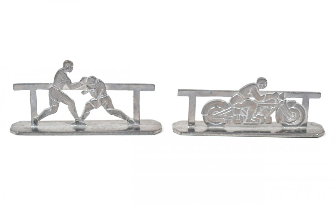 Two Art Moderne Paperweights: Each silver-metal example mounted with sports motifs. 1.) boxers. 2.) motorcyclist. [4"L]