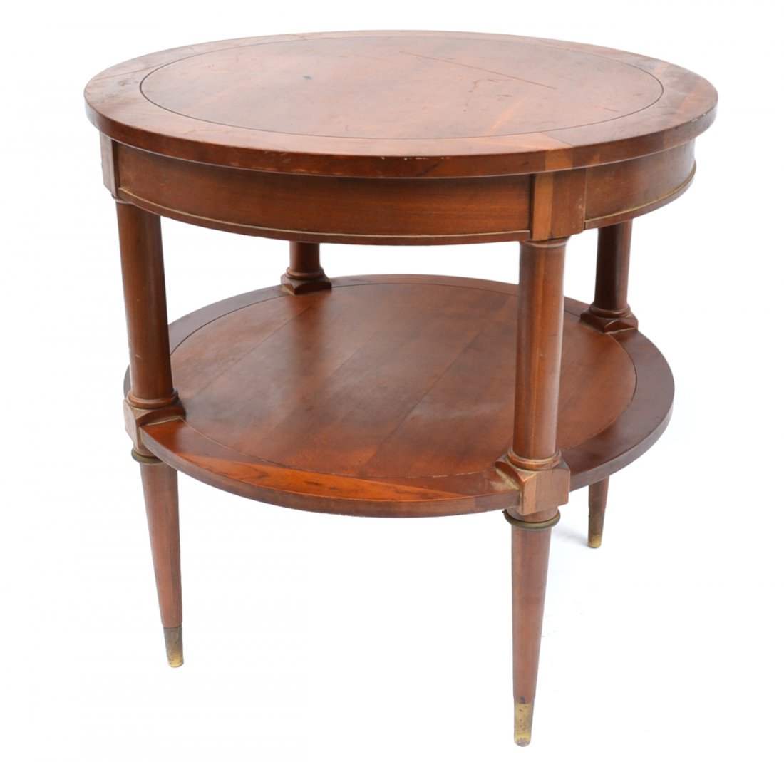 Brandt Louis XVI-Style Side Table: Two-tier mahogany side table on sabot feet. [26" Dia x 26 1/8" H]. Brandt label on bottom. Top bears two burn marks and deep scratch, otherwise light wear throughout.