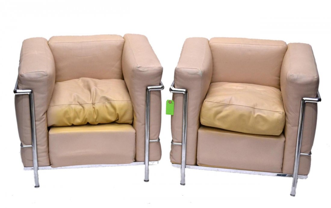 Pair of Le Corbusier LC2 Chairs: 'Grand Confort, Petit Modele', manufactured by Cassina. [29" W x 27" D x 28" H]. Tan leather cushions bearing scratches along with a torn seam.
