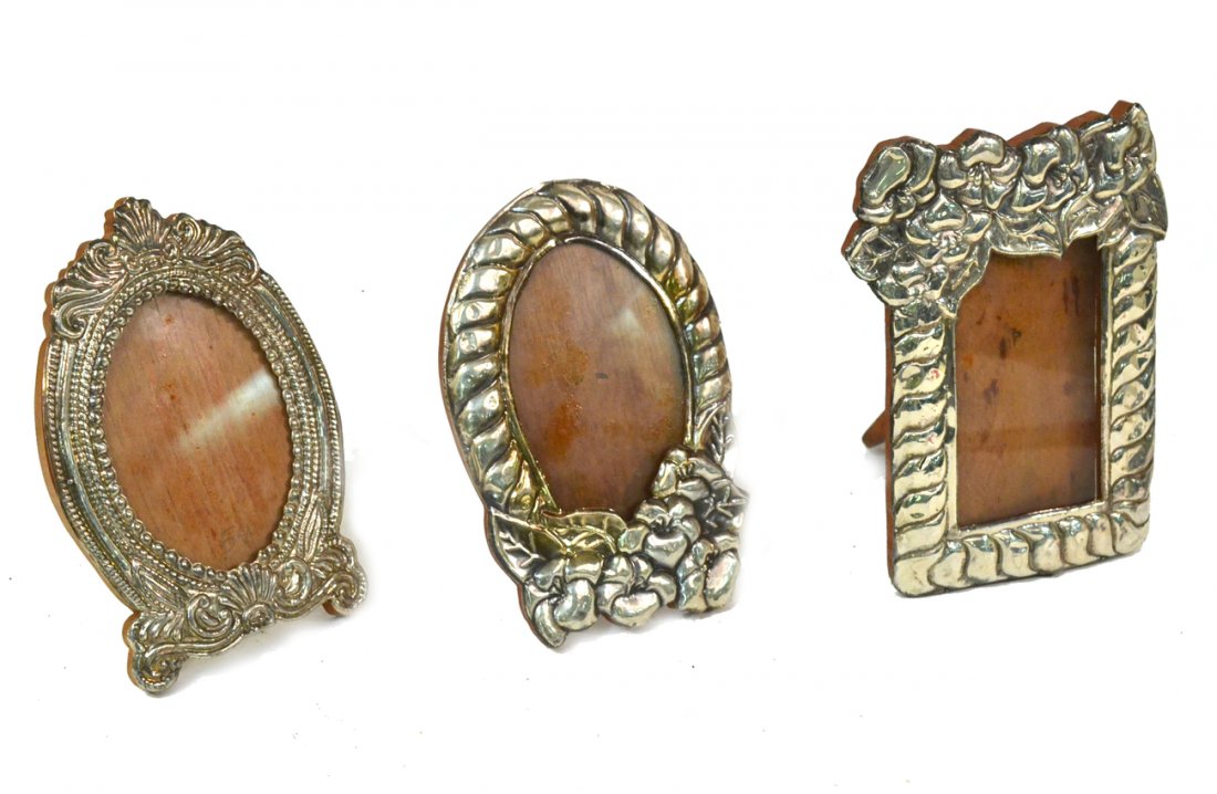 Three Silver Picture Frames: Repoussé silver picture frames with wood supports and struts. [Largest: 6 3/8" W x 8 1/2" H]. All bear shallow dents.
