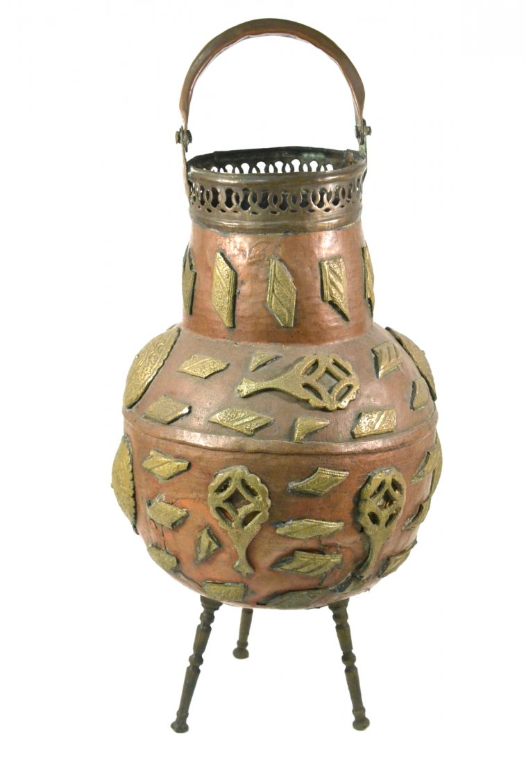 Middle Eastern Mixed Metal Brazier: Copper vessel having thick brass decorative appliques and tripod base. [25" H]. Major repair to body of brazier.