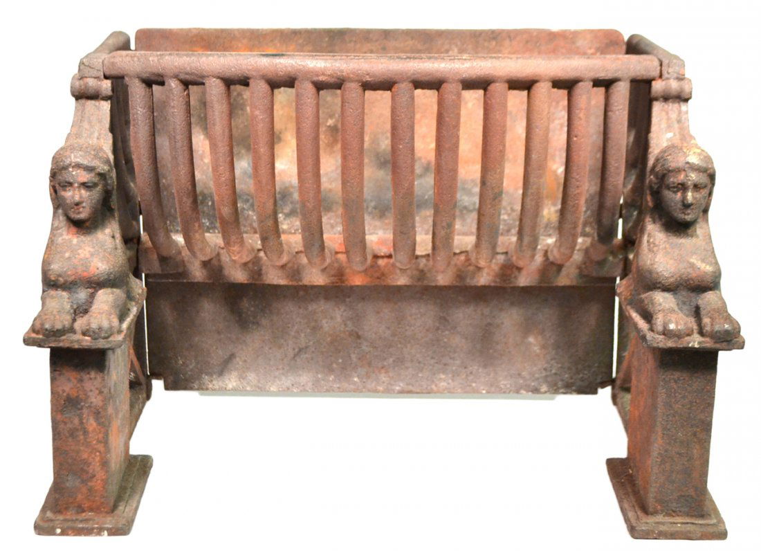 Antique Fireplace Coal Grate: Empire/Egyptian Revival cast iron fireplace coal grate. Features sphinx supports on either side on plinth bases. [17 1/2" W x 11" D x 11 3/8" H]. Oxidation and wear, otherwise structurally sound.