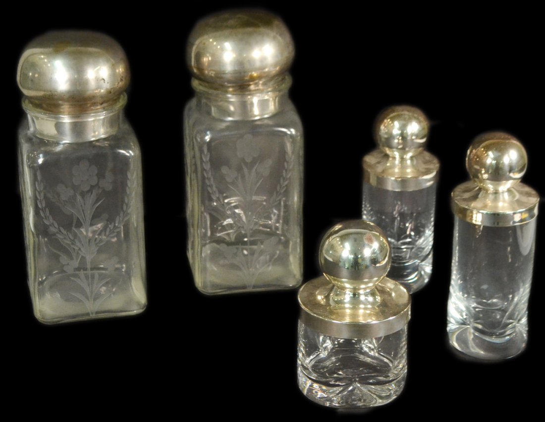 Five Glass and Metal Jars: Includes pair of large square etched glass jars with silvered metal stoppers, and a set of three "pinched" glass dresser jars. [Largest: 12"]. Wear to metal plating.