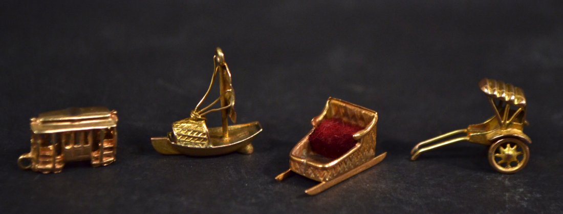 Four 14k Gold Charms: Comprises sled, rickshaw, train car, and Chinese junk. Good condition. 4.9 dwt.