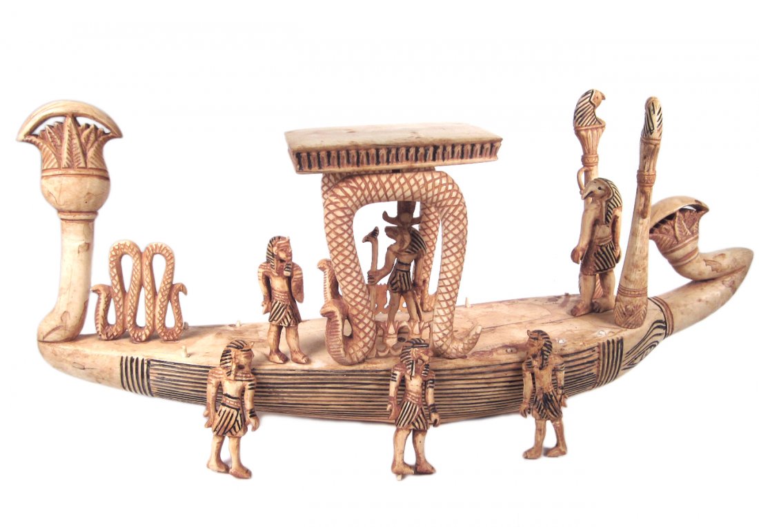 Egyptian Revival Style Bone & Ivory Boat: Ceremonial ship with six carved figures, gazebo with snake supports and incised accents. [15 1/4" W x 3 1/8" D x 6 3/4" H]. Sold "as is". Ivory and bone elements dispersed throughout.