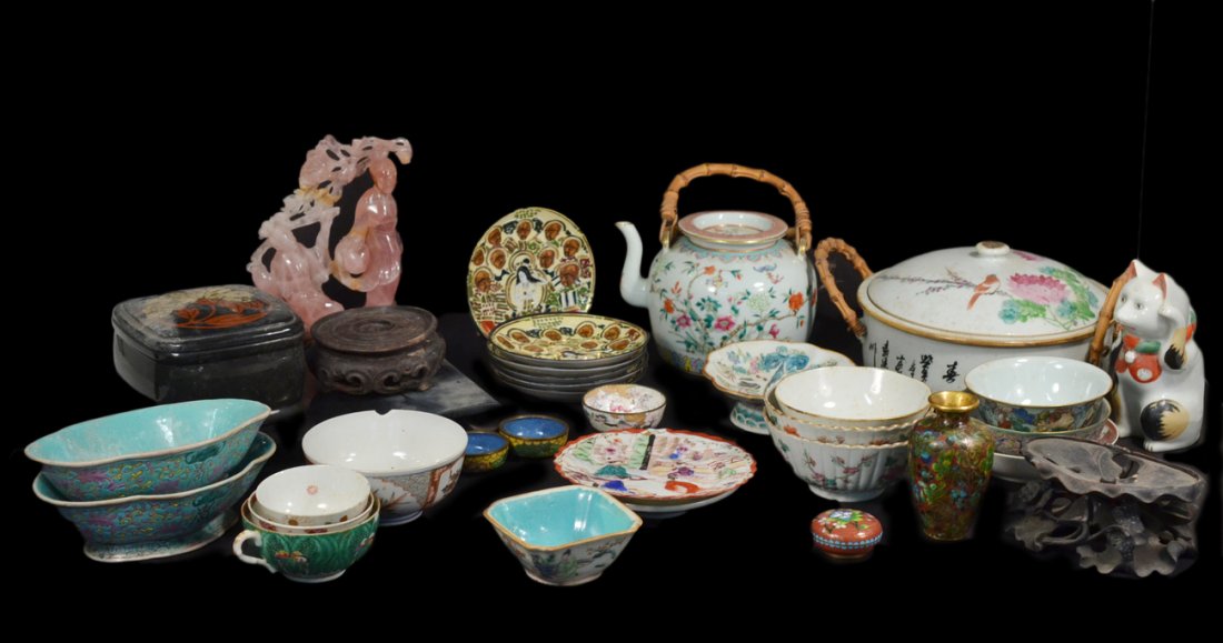 Group of 28 Asian Decorations: Includes a variety of porcelain tableware, a rose quartz carving with extensive restoration, cloisonne, lacquer and wood stands. Conditions vary.
