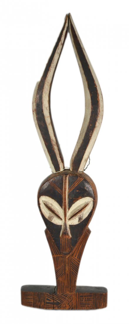 Two-Sided Aboriginal Sculpture: Carved and painted head with horns and geometric decoration. [26" H]. Older repair to base.