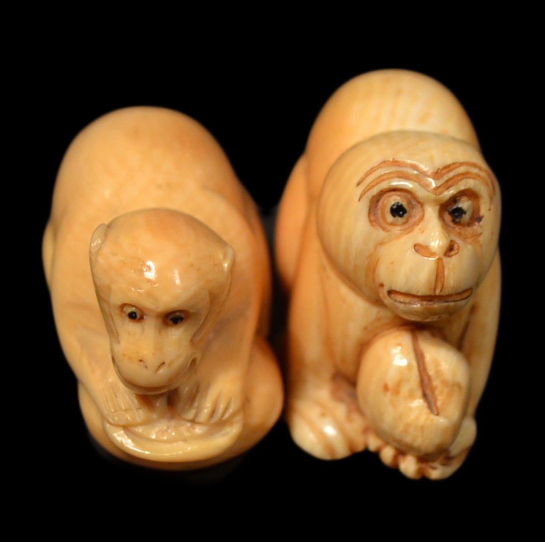 Two Antique Ivory Netsukes - Monkeys: Each depicts a crouching monkey; one with fruit. [1 1/2"W x 1 1/4"H x 3/4"W]. Both in good condition.