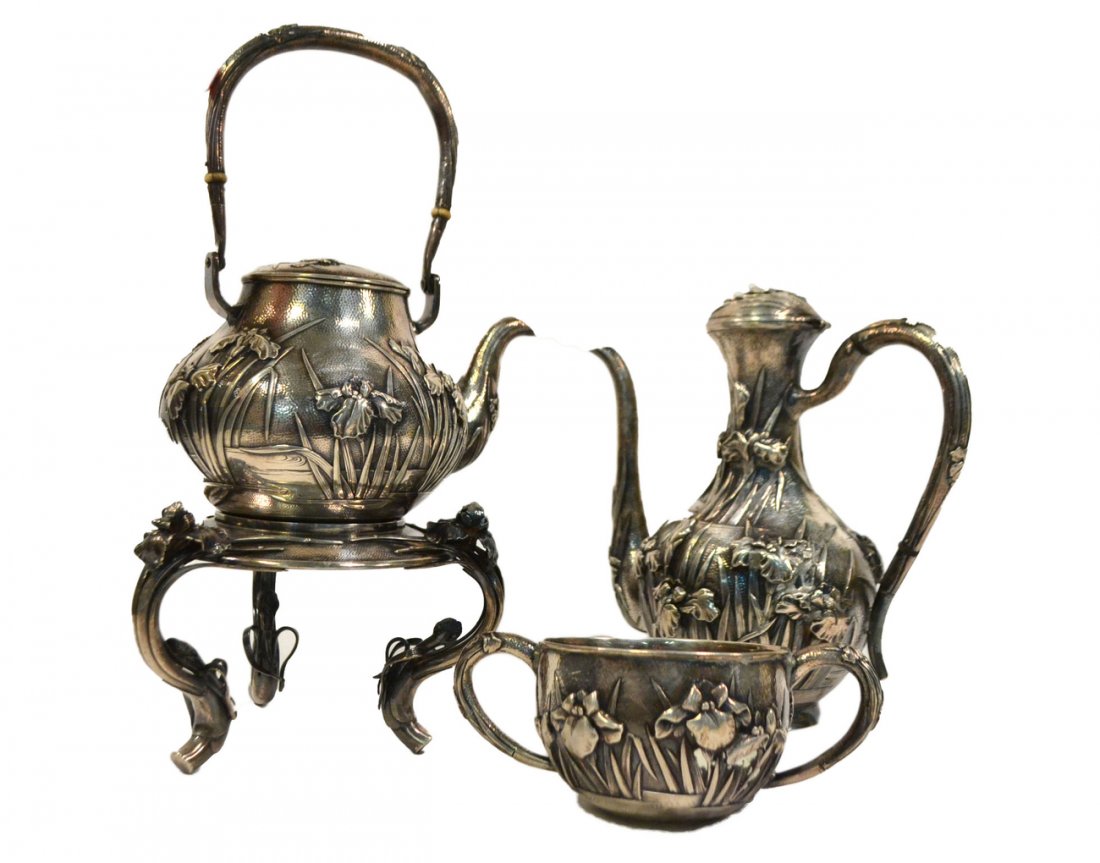 Japanese 3 Piece Meiji Coffee Service: All beautifully embellished with chased and applied bearded iris. Comprises: Kettle on stand, coffee pot, and open sugar bowl. All pieces signed. [Coffee pot: 9" H]. 65.65 ozt. Sugar bowl damaged at b