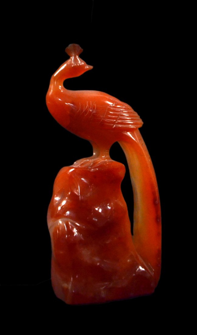 Chinese Carnelian Carving of a Peacock: Depicts a peacock at rest on a rock formation. [2" W x 1 1/8" D x 4 3/8" H]. Complete and in good condition.