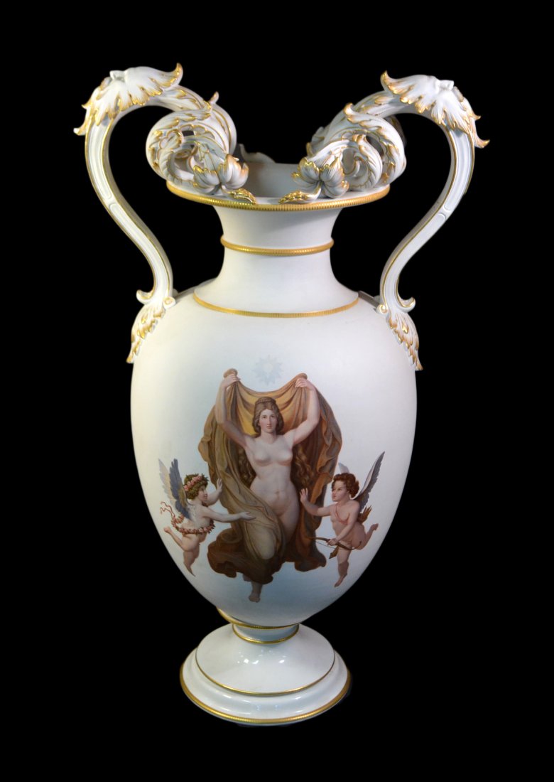 KPM Porcelain Vase: Matte glaze vase with gilt accents featuring an allegorical female nude flanked by two cupids and ornate scrolling double handles with leafy decor and bearded masks. [15 1/2" W x 11 1/2" D x 25 3/4" H