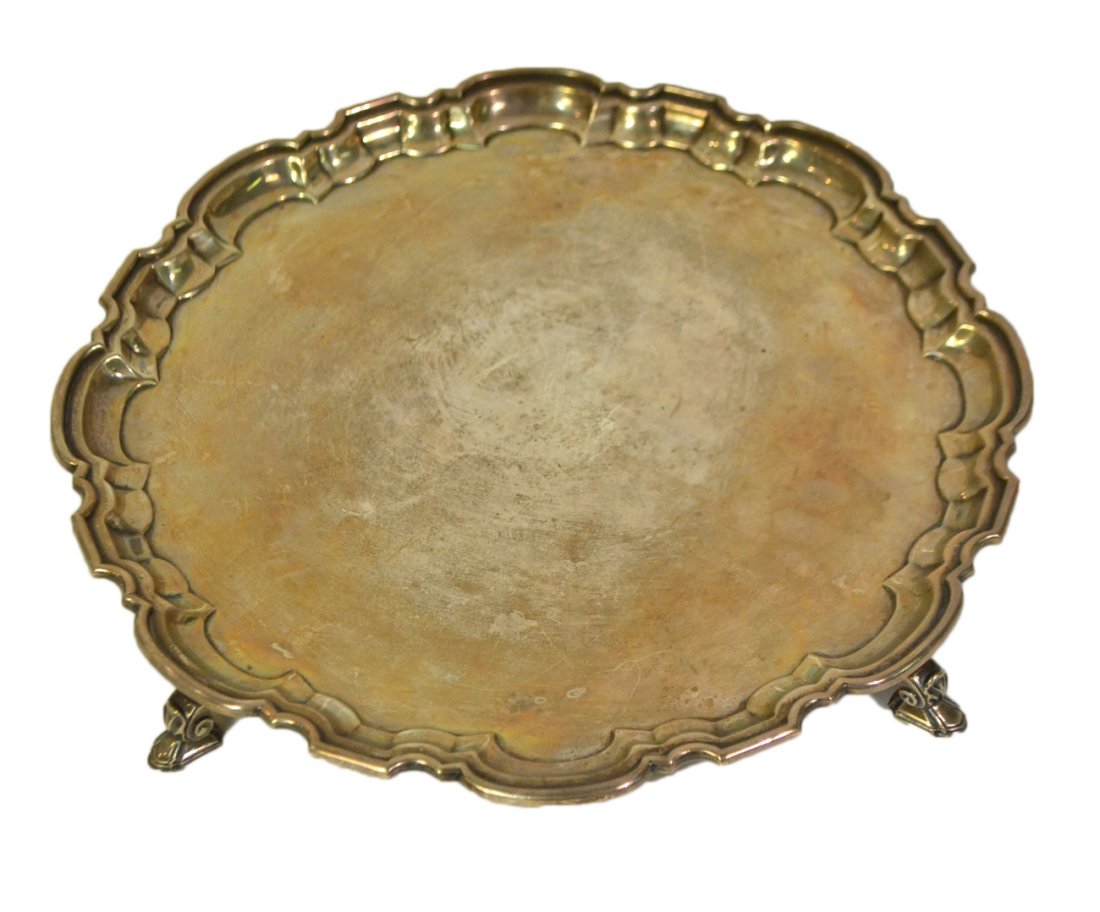 Mappin and Webb Sterling Salver: The circular salver with shaped "pie crust" edge and raised on four pad feet. Numerous light scratches. 27.17 ozt.